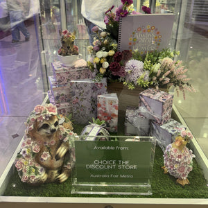 Decorative items including small bears and floral arrangements in a glass display case.